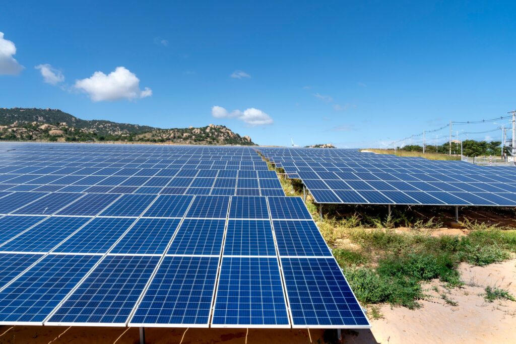 Stort solcelleanlæg på mark i solskin, koblet til energilager til virksomheder