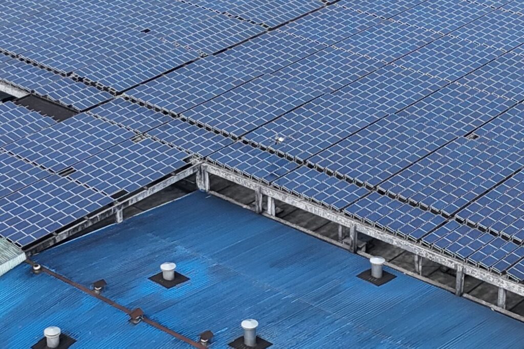 Solceller på industritag set fra luften, kombineret med batteri til erhverv